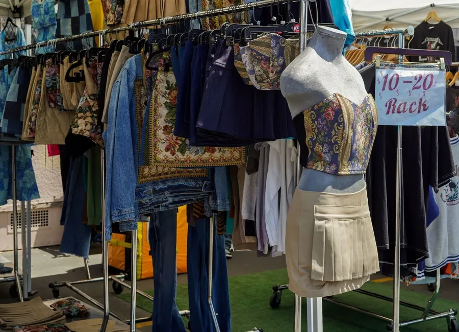 Étal de vide-grenier vintage dans les Deux-Sèvres avec vêtements, sacs et linge ancien exposés au petit matin